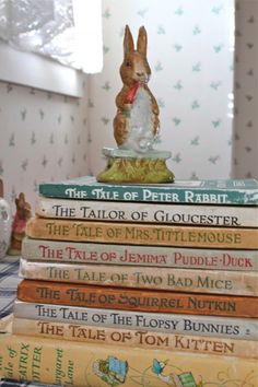 a stack of books with a rabbit figurine sitting on top of one another