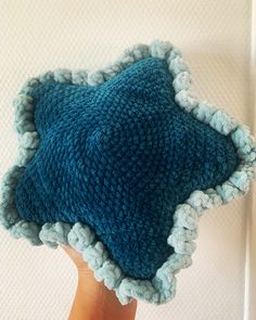 a hand holding a blue and white knitted hat