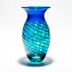 a blue glass vase sitting on top of a white table