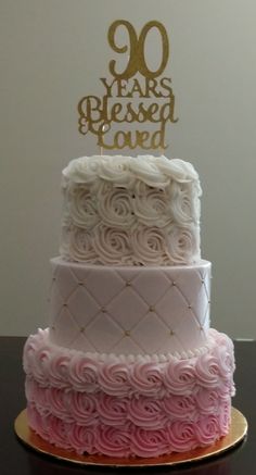 a three tiered cake with pink and white frosting on top that says 90 years passed loved