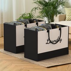 two black and white shopping bags sitting on top of a rug next to a potted plant