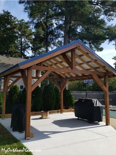 a wooden gazebo sitting on top of a cement patio next to a swimming pool