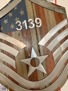 a wooden shield with an american flag and the number 3819 on it's side