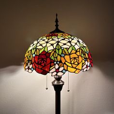 a lamp that is on top of a wooden table with a flower design on it