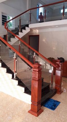 there is a stair case with glass railings on the top and bottom floors in this house