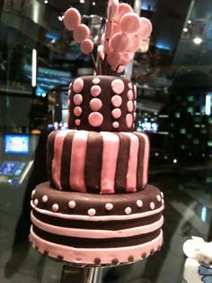 a three tiered cake with pink and brown icing