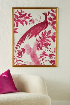 a pink and white painting hangs on the wall next to a chair with a purple pillow