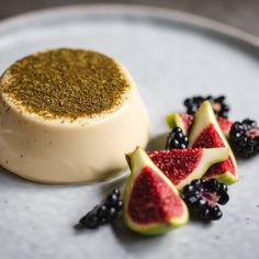 a white plate topped with dessert next to berries and other toppings on top of it