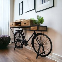 an old bicycle is sitting on the floor next to a wall with pictures above it