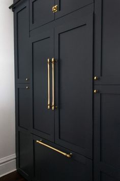 a black cabinet with brass handles and knobs on the doors is shown in this image