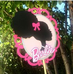 a pink and black cake topper with a silhouette of a woman's head