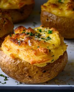 baked potatoes with cheese and herbs on a tray