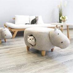 a cat is sitting in a hippo chair with two stuffed animals on the floor