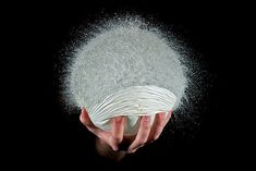 a person's hand holding an object with powder coming out of it