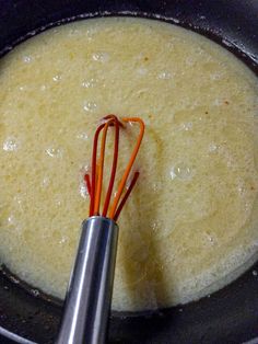 the whisk is being stirred in the pot with an orange and red wire