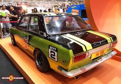 a green and yellow car is on display