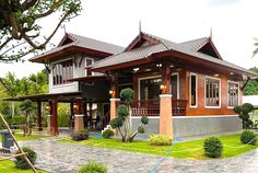 the house is made of wood and has lots of green plants on the front lawn