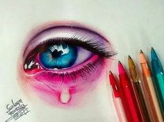 a drawing of an eye with colored pencils next to it