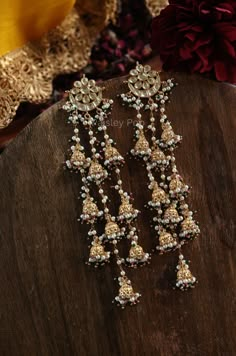 Experience the beauty of blooming flowers with these floral kundan earrings. Adorned with delicate jhumkis of elegance and highlighted by pearls and green hydro stones, these earrings exude impeccable craftsmanship and divine allure. Perfect for adding a touch of grace and purity to any outfit. Closure - Push Back Bollywood Style Gota Work Danglers For Reception, Fusion Kundan Jhumkas With Gota Work, Fusion Style Kundan Jhumkas With Gota Work, Traditional Danglers With Latkans For Reception, Kundan Fusion Dangle Jhumkas, Fusion Kundan Chandelier Earrings With Latkans, Fusion Style Kundan Chandelier Earrings With Latkans, Fusion Style Kundan Dangle Jhumkas, Temple Jewelry Latkans Earrings For Reception