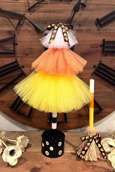 a clock with a yellow and orange dress on it's face, surrounded by other decorations