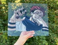 a hand holding up a drawing of an anime character