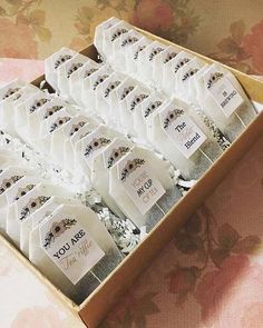 a box filled with lots of white chocolates on top of a pink table cloth