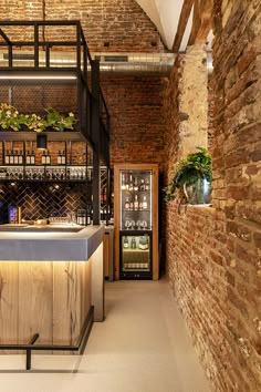 the bar is next to an old brick wall with shelves full of bottles and glasses