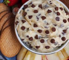 a bowl filled with ice cream next to crackers and strawberries