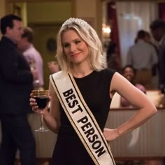 a woman in a black dress holding a glass of wine