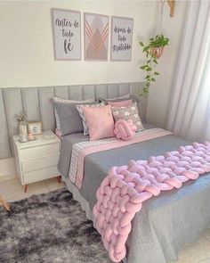 a bedroom with pink and grey decor on the walls, bedding and rugs