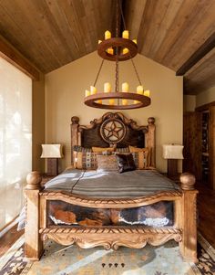 a large bed sitting inside of a bedroom under a chandelier with candles on it