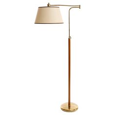 a wooden floor lamp with a white shade