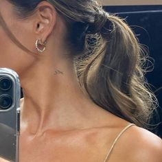 a woman taking a selfie with her cell phone in front of her earring