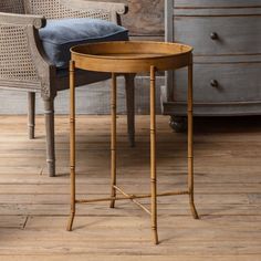 a wooden table sitting on top of a hard wood floor next to a chair and dresser