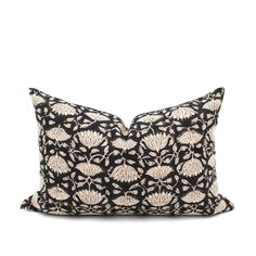 a black and white pillow with an intricate design on the front, sitting against a white background