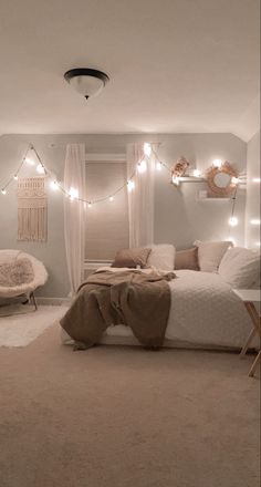 a bedroom decorated in neutral tones with lights on the ceiling and bedding, rugs and pillows