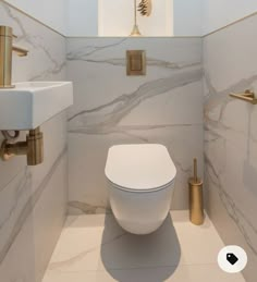 a white toilet sitting inside of a bathroom next to a wall mounted faucet