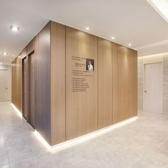 an empty room with wooden walls and white tile flooring is lit by recessed lighting