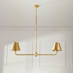 a light fixture hanging from the ceiling in a room with white walls and wood flooring