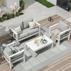 an aerial view of a patio with white furniture and flowers on the coffee table in the center