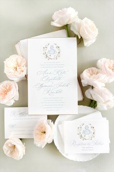 the wedding stationery is laid out on top of each other, with white flowers