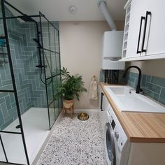 a washer and dryer in a small room with blue tiles on the walls