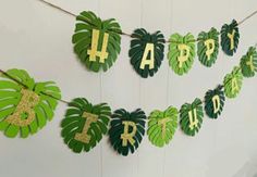 a happy birthday banner made out of green leaves