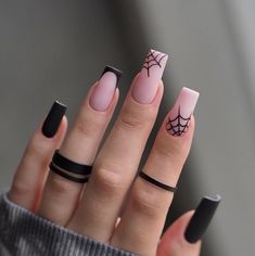 a woman's hand with some black and pink nail polishes on her nails