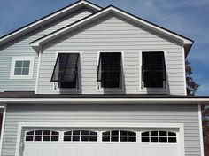 a white house with three windows and shutters