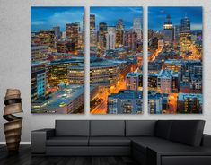 the cityscape is lit up at night in this modern living room wall art