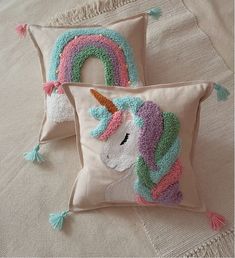 two pillows that have been made to look like an unicorn and a rainbow on them