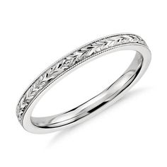 a white gold wedding ring with intricate engraving