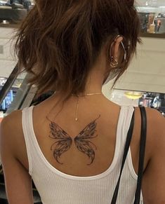 a woman with a butterfly tattoo on her back