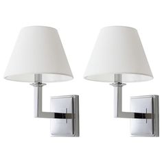 two white lamps mounted on a wall next to each other